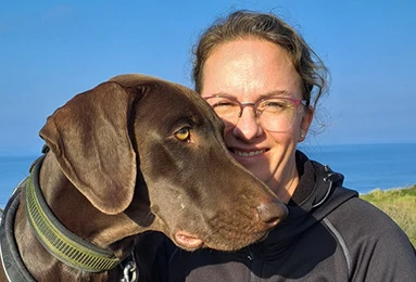 Ein Foto von Gina Meister mit ihren beiden Schäferhunden Tango und Texas an den Seiten und ihren gewonnen Pokalen